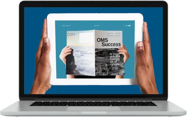 A tablet showing OMS Success magazine, held up in front of a laptop screen